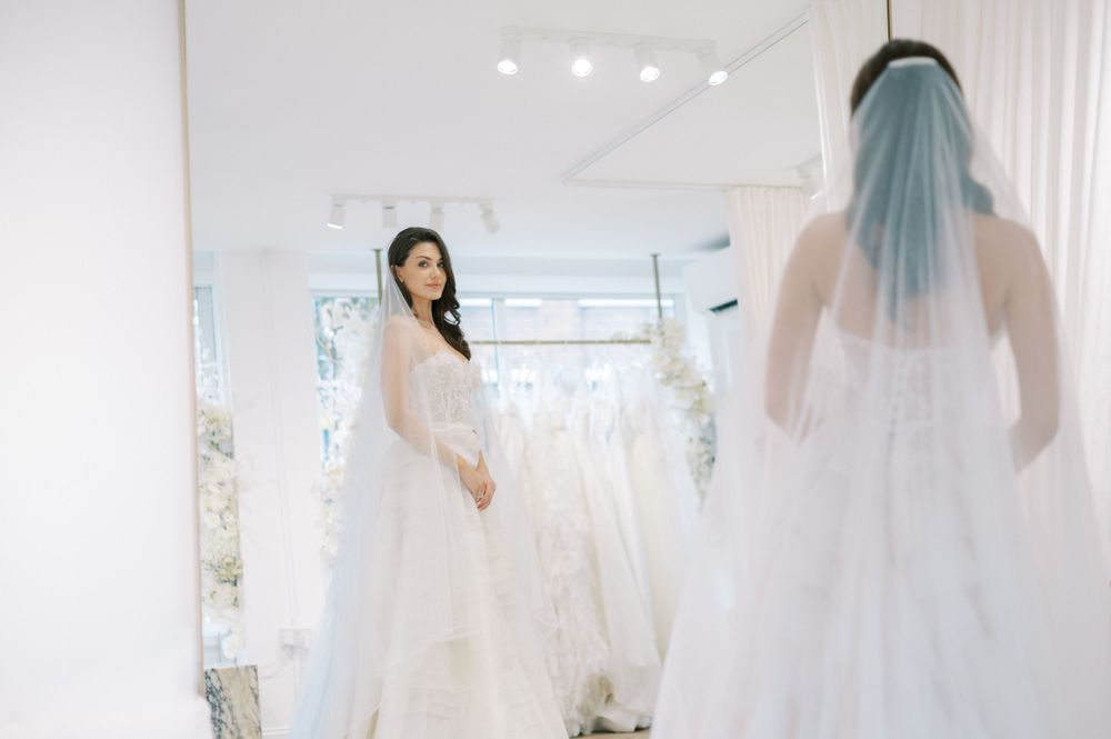 Wedding dress display in a bright, modern bridal boutique with white decor.