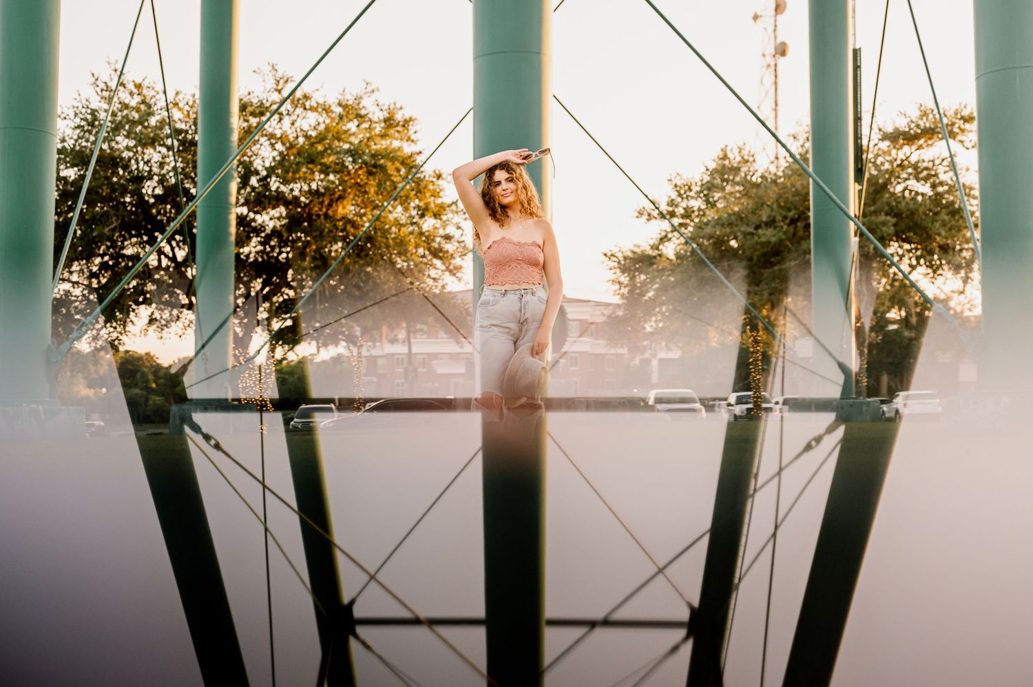 A sunset portrait through architectural elements creating dramatic silhouettes and reflections.