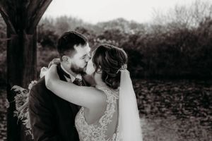 An intimate black and white portrait of a couple embracing during their wedding ceremony.