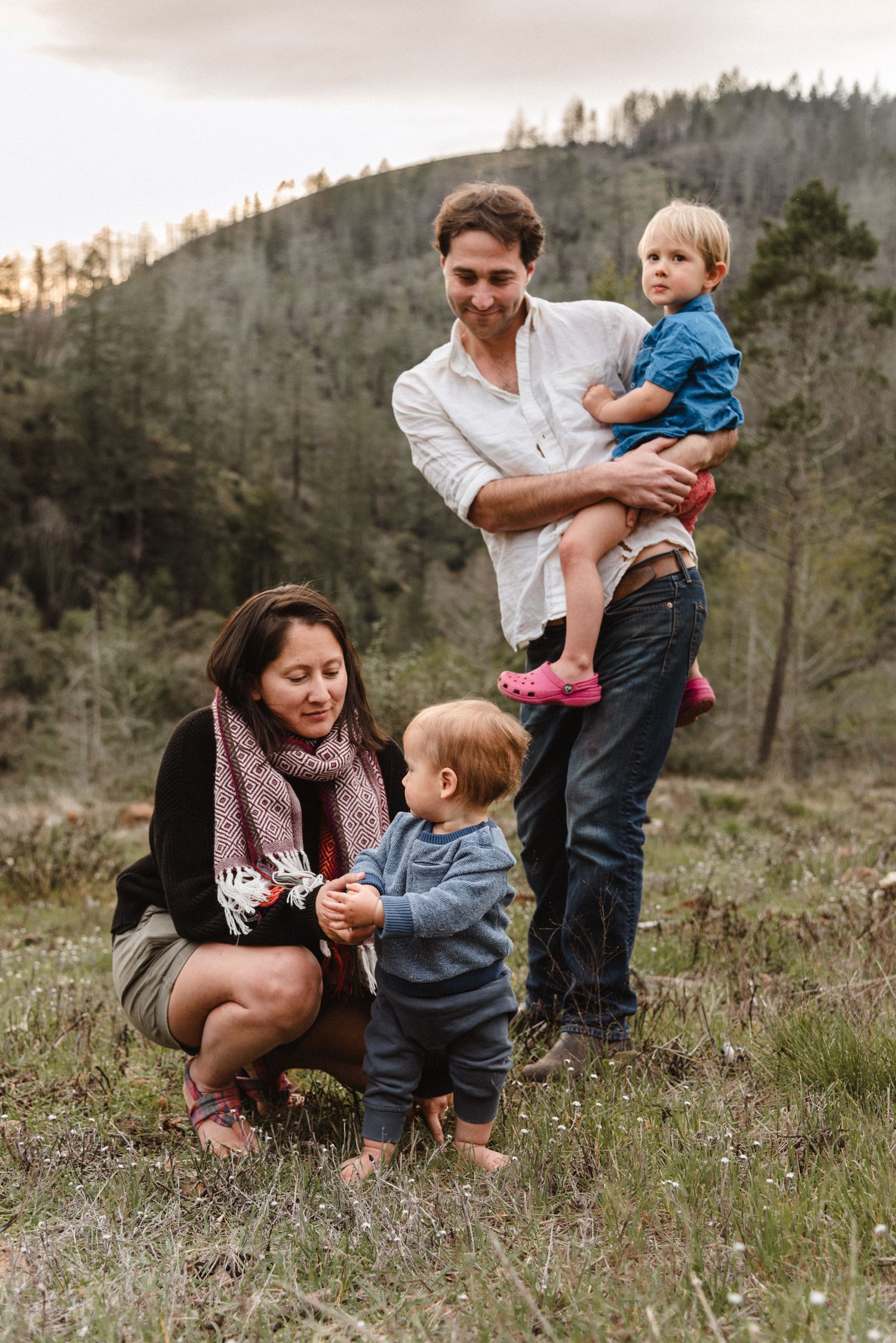 Family spending time together in a mountainous landscape during golden hour.