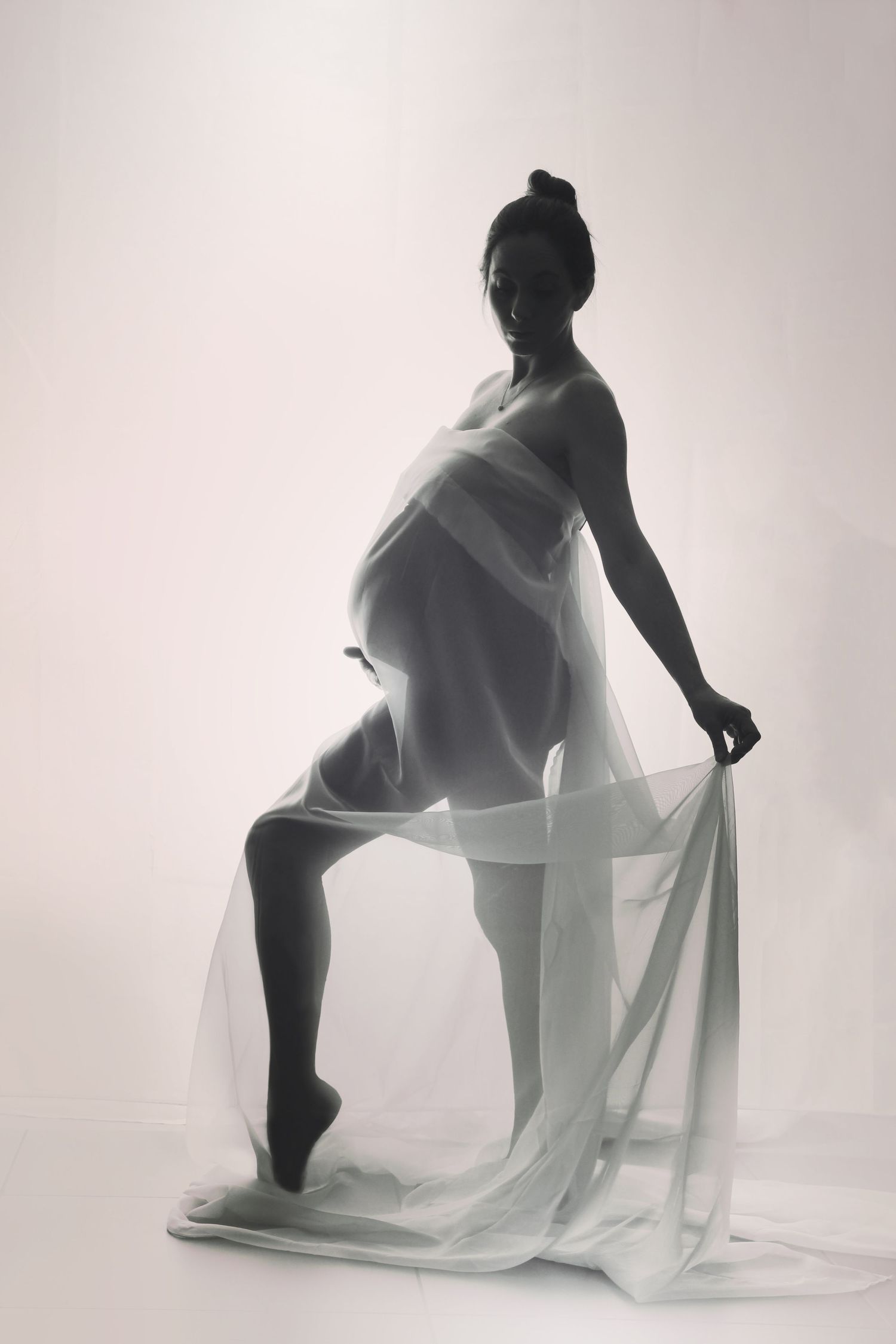Elegant Fine Art Maternity Shoot, pregnant mum-to-be, draped in white chiffon, back lit black & white maternity shoot