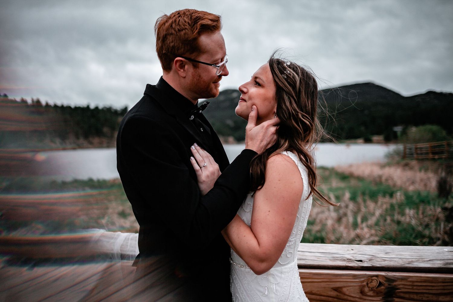 Intimate moment between newlyweds on deck overlooking mountain landscape. Denver Wedding Photography.