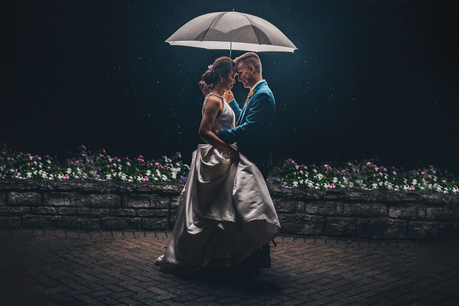 A romantic rainy evening portrait of a couple sharing an intimate moment under an umbrella.