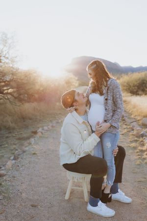 A tender moment captured between two people on a desert trail at sunset.
