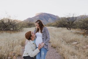 A romantic desert photoshoot with mountains and desert vegetation in the background.