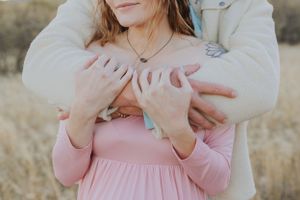 Close-up shot of a couple holding hands against a desert mountain backdrop.