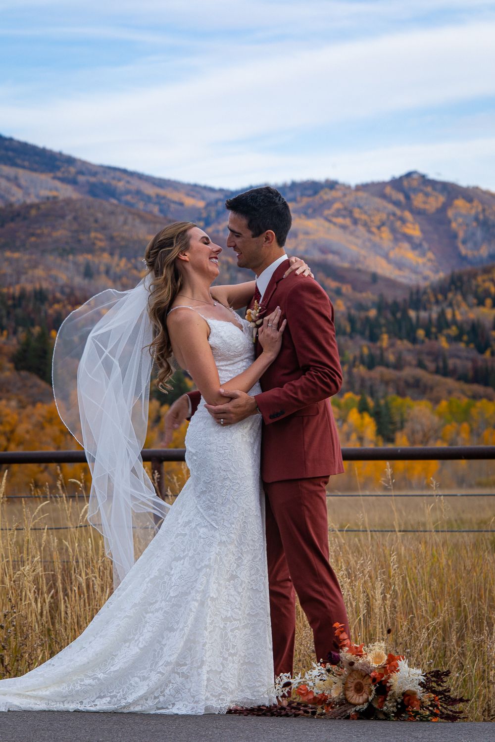 Newlyweds embrace against a backdrop of mountain vistas and fall foliage.