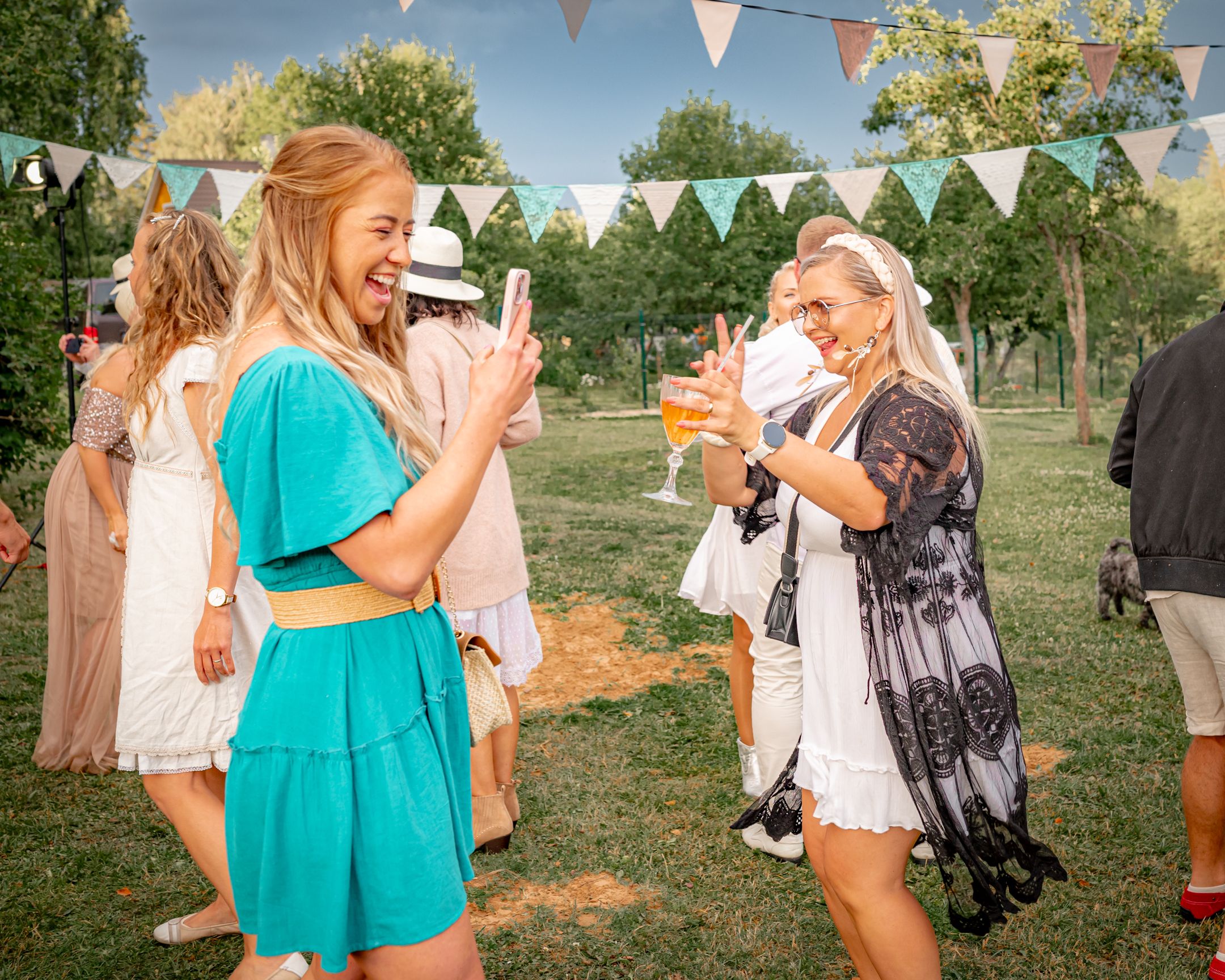 Friends enjoying drinks and conversation at a sunny outdoor garden party.