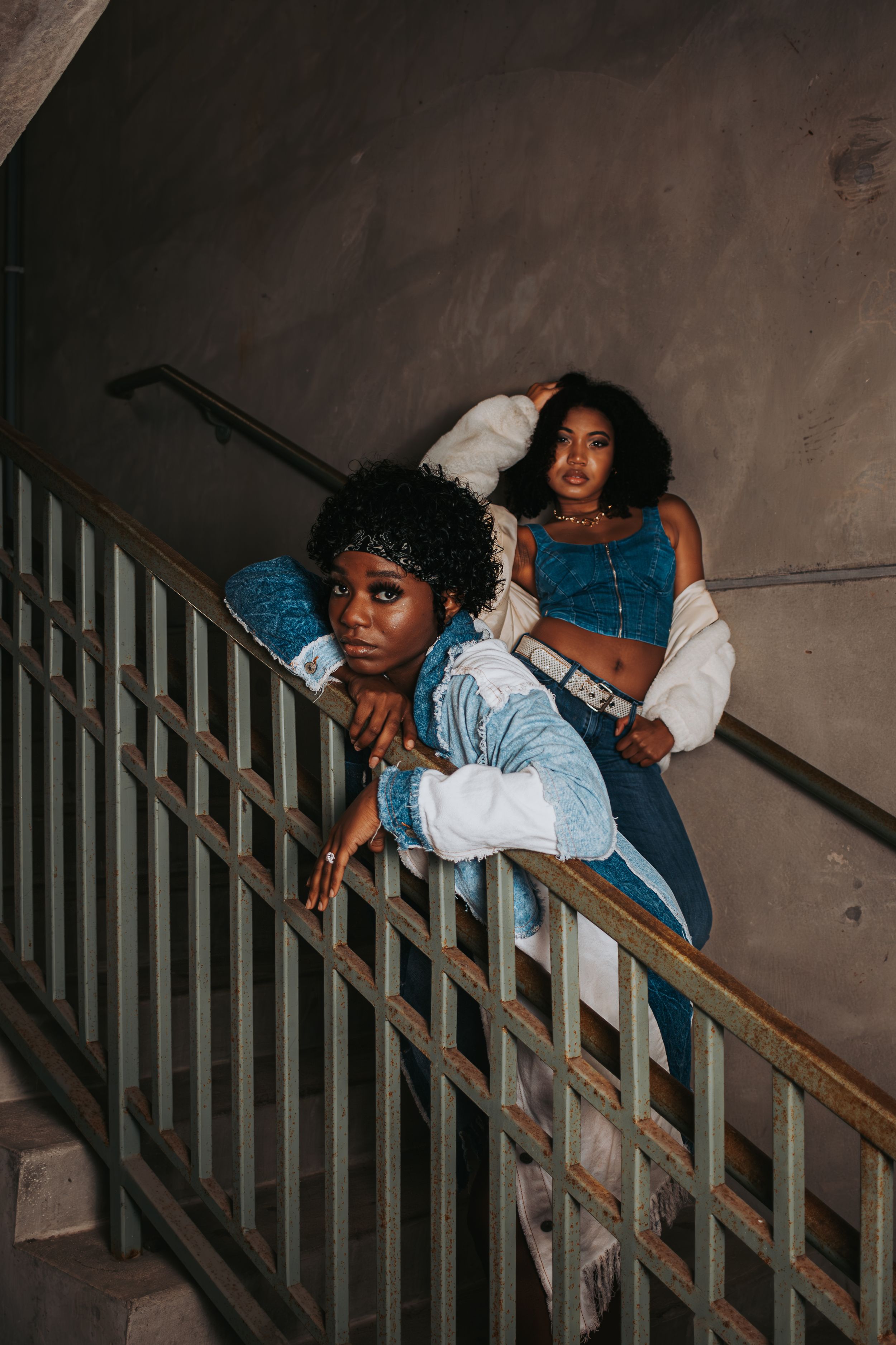 Creative portrait of someone posed along a concrete stairway railing.