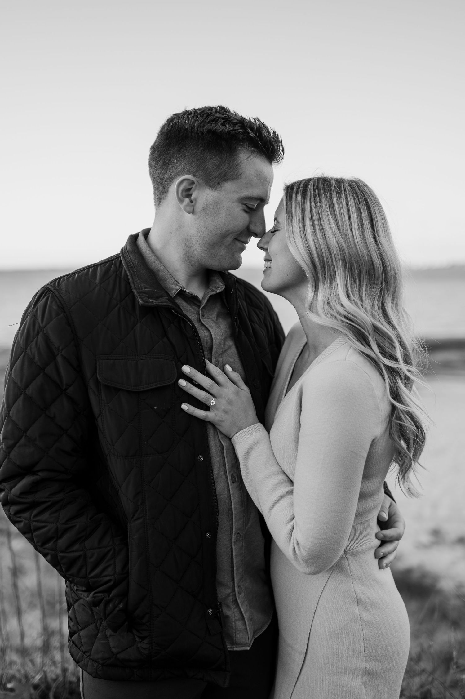 Black and white portrait of couple sharing intimate moment outdoors.