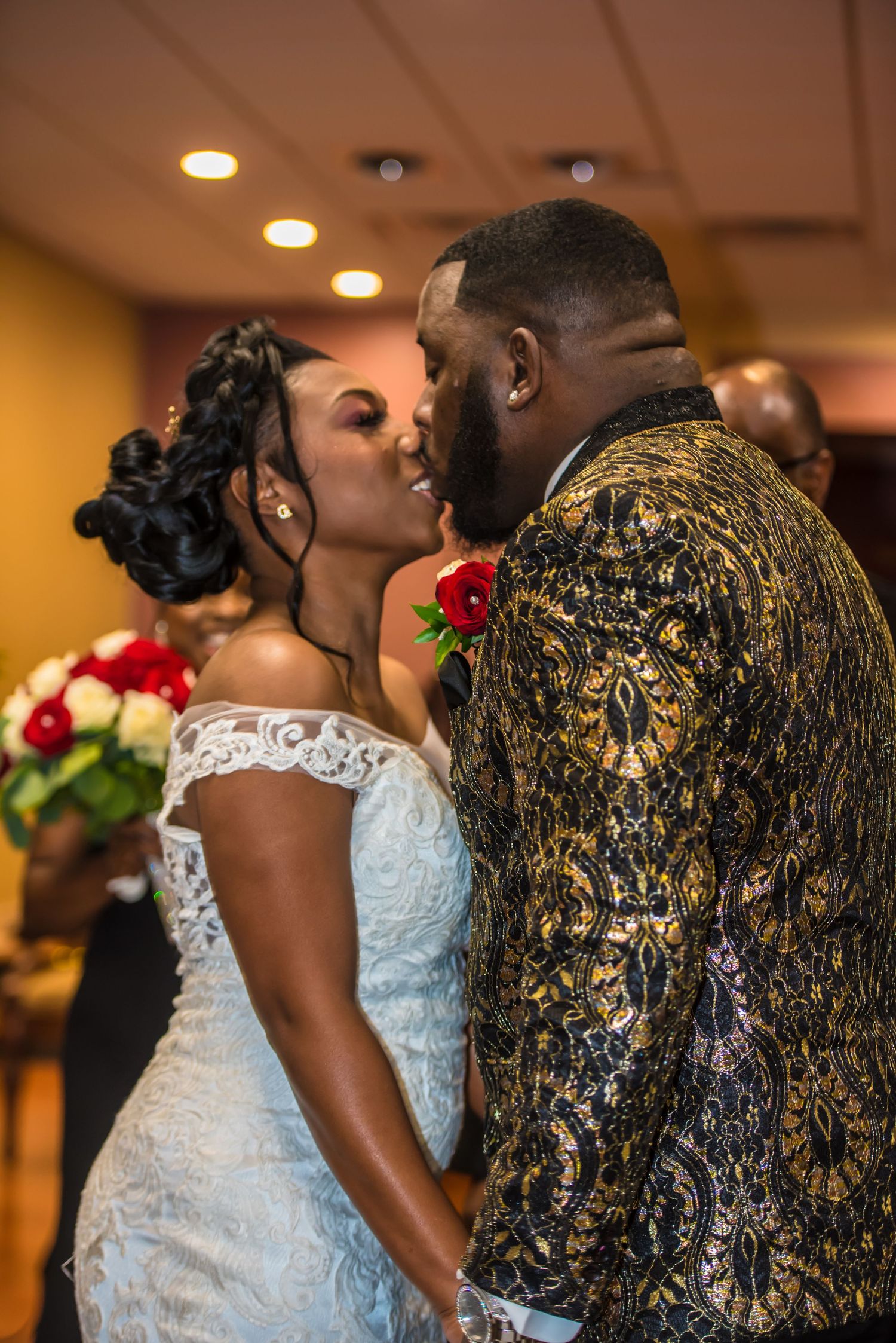 A wedding celebration showing details of lace dresses and formal attire in warm indoor lighting.