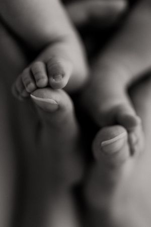 Close-up black and white image of tiny baby feet in soft focus.