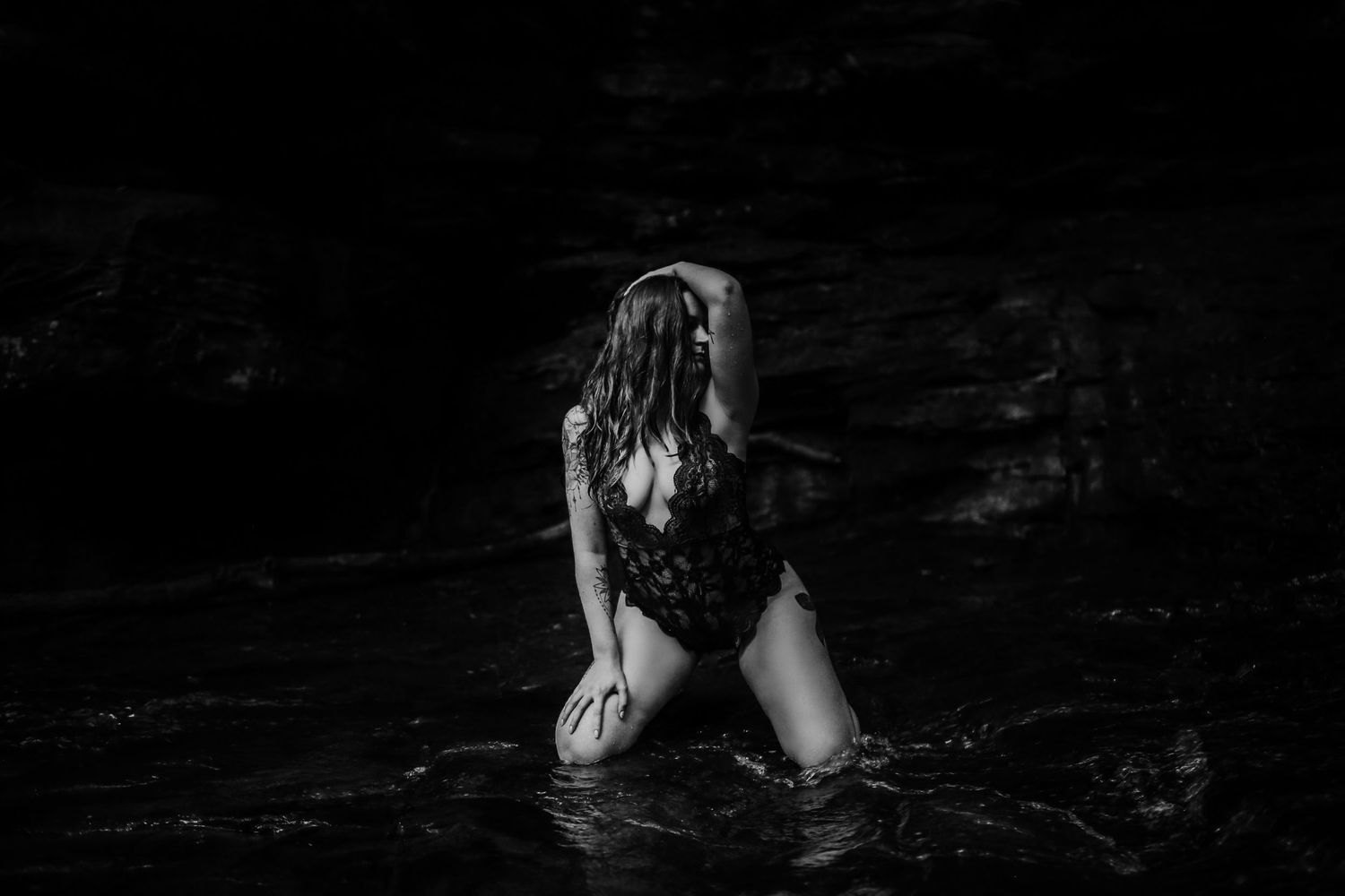 Dark artistic black and white photo of splashing water and dramatic shadows.