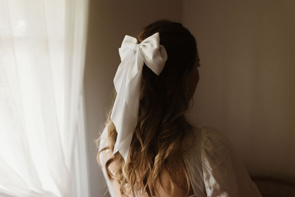 Bride with white bow in hair, image of back of head