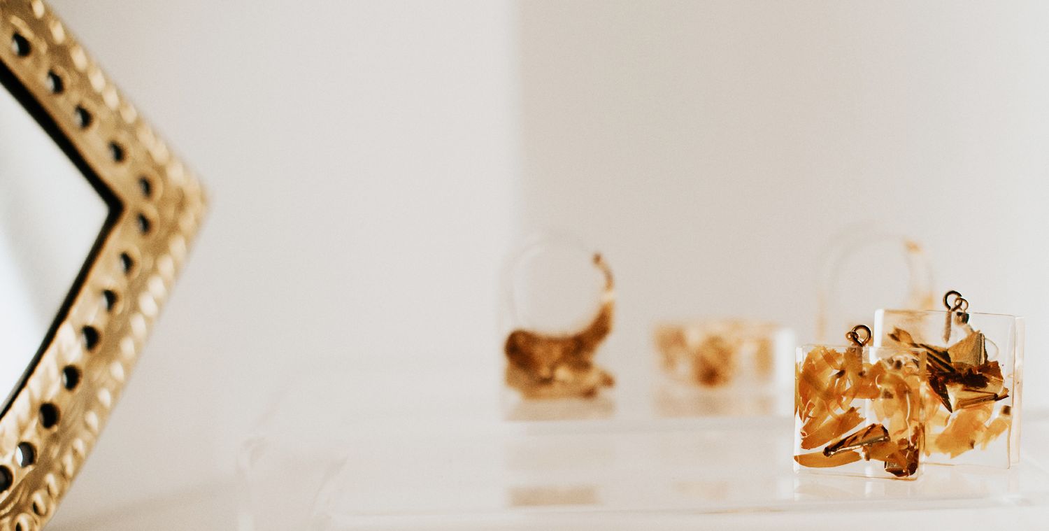 Crystal clear gemstones or jewelry pieces arranged on a white surface with soft focus.