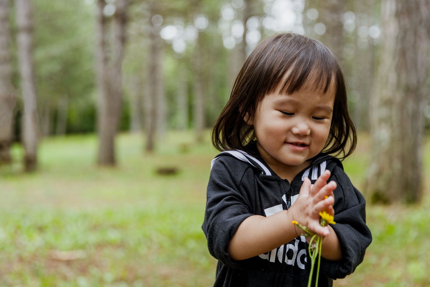 Hmong child playing in nature with flowers.