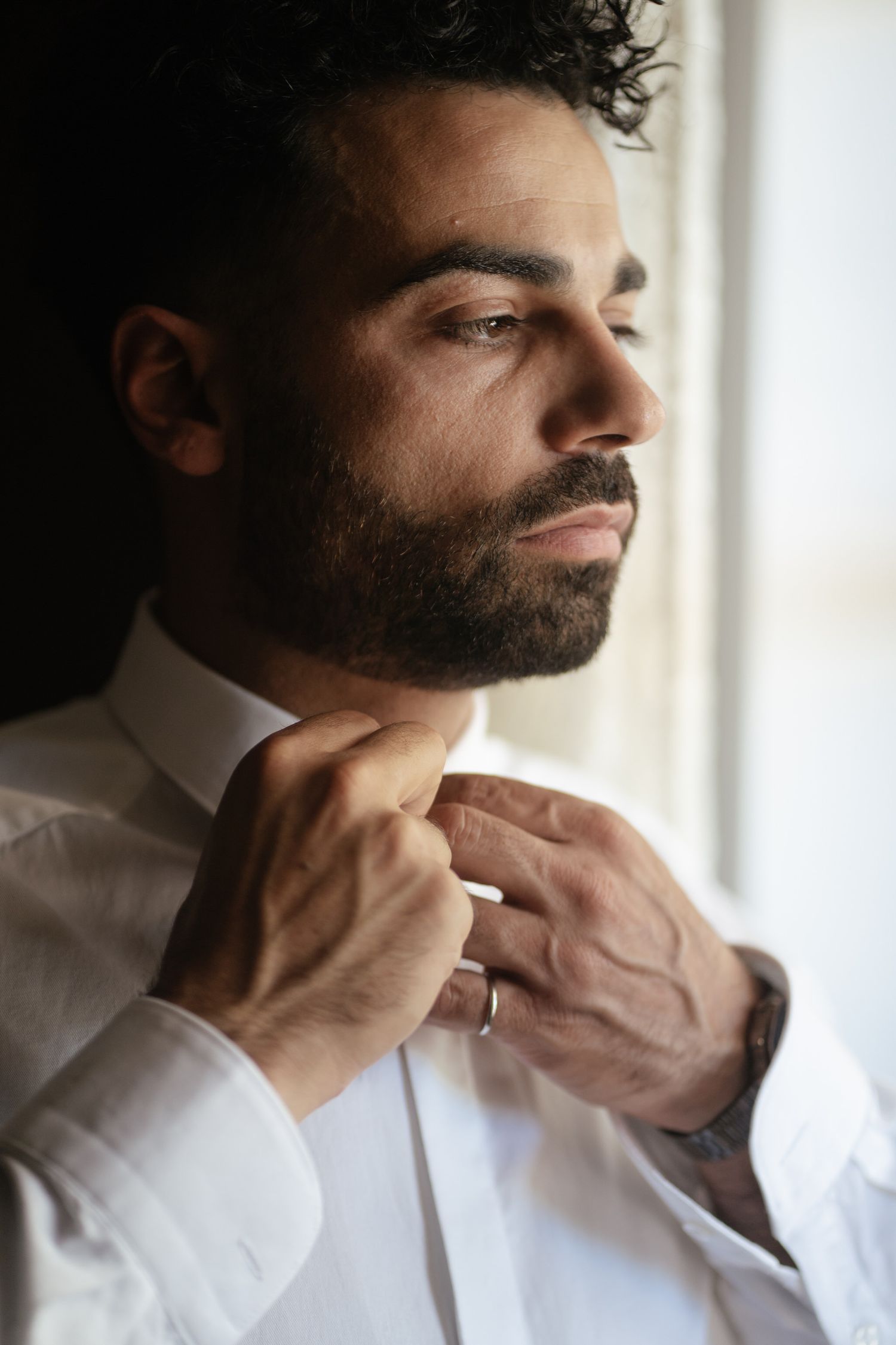 A series of close-up shots showing someone adjusting their collar in a white dress shirt.