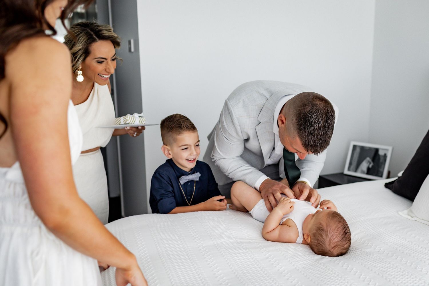 A sweet family moment captured during a special occasion in a bright bedroom.
