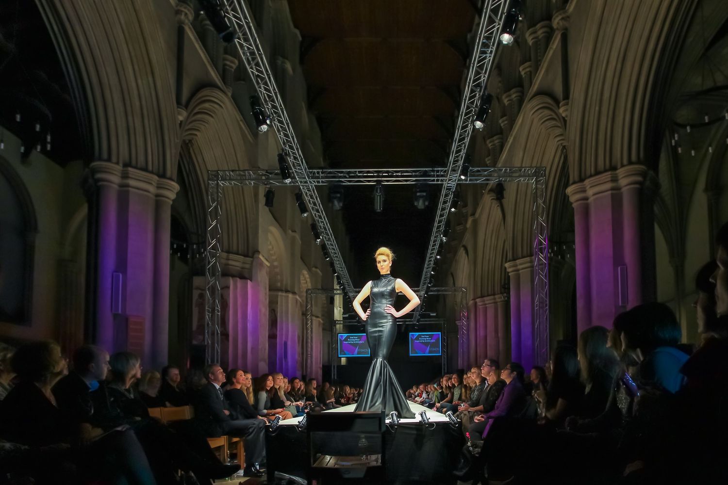 A female model from Oaklands College stands at the end of St Albans Fashion Show catwalk in St Albans Abbey Cathedral