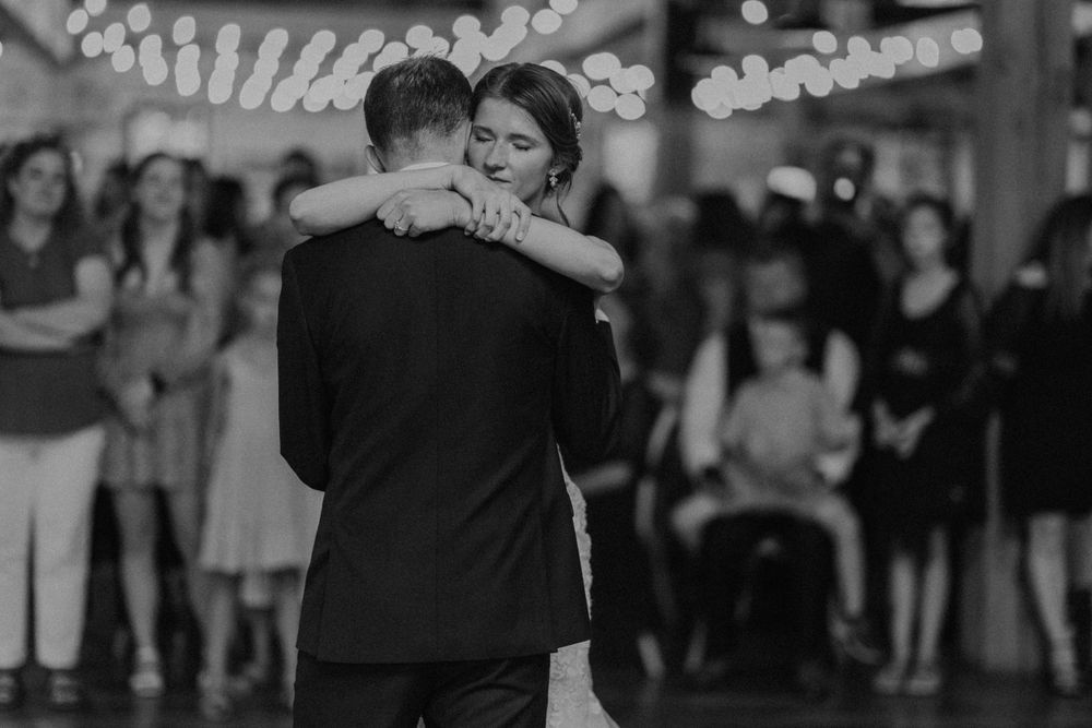 Black and white photo of bride and groom sharing an emotional first dance at their wedding reception.