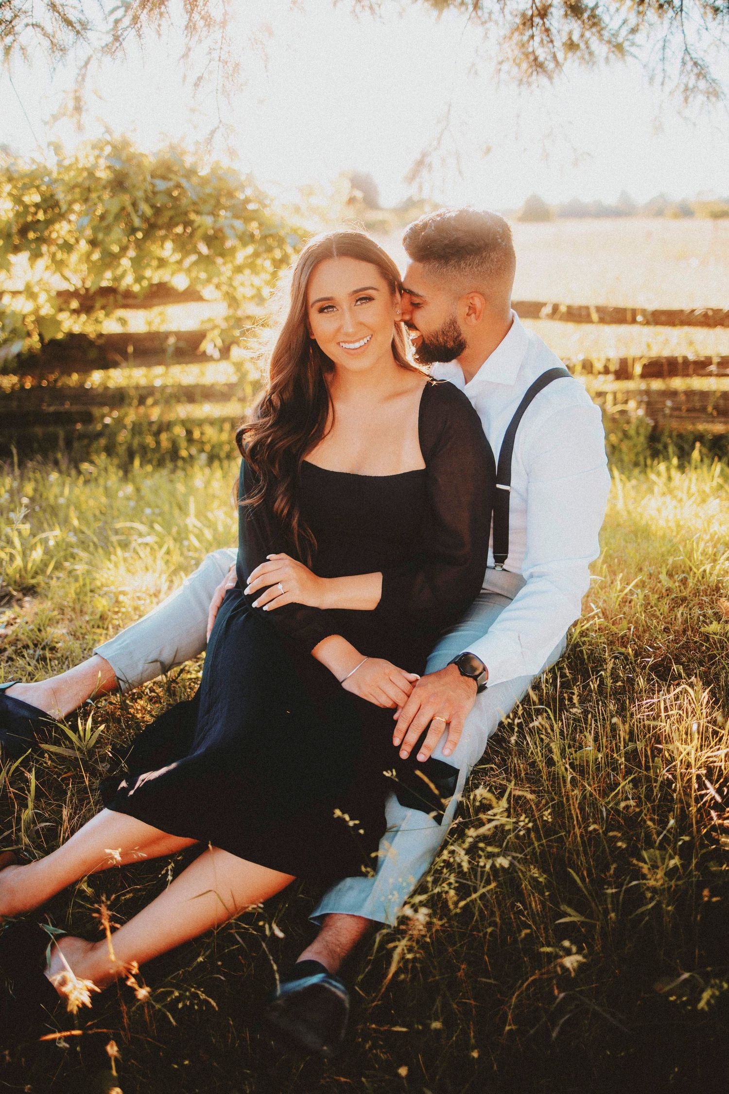 Casual couples portrait session in a sunlit field with warm golden hour lighting.