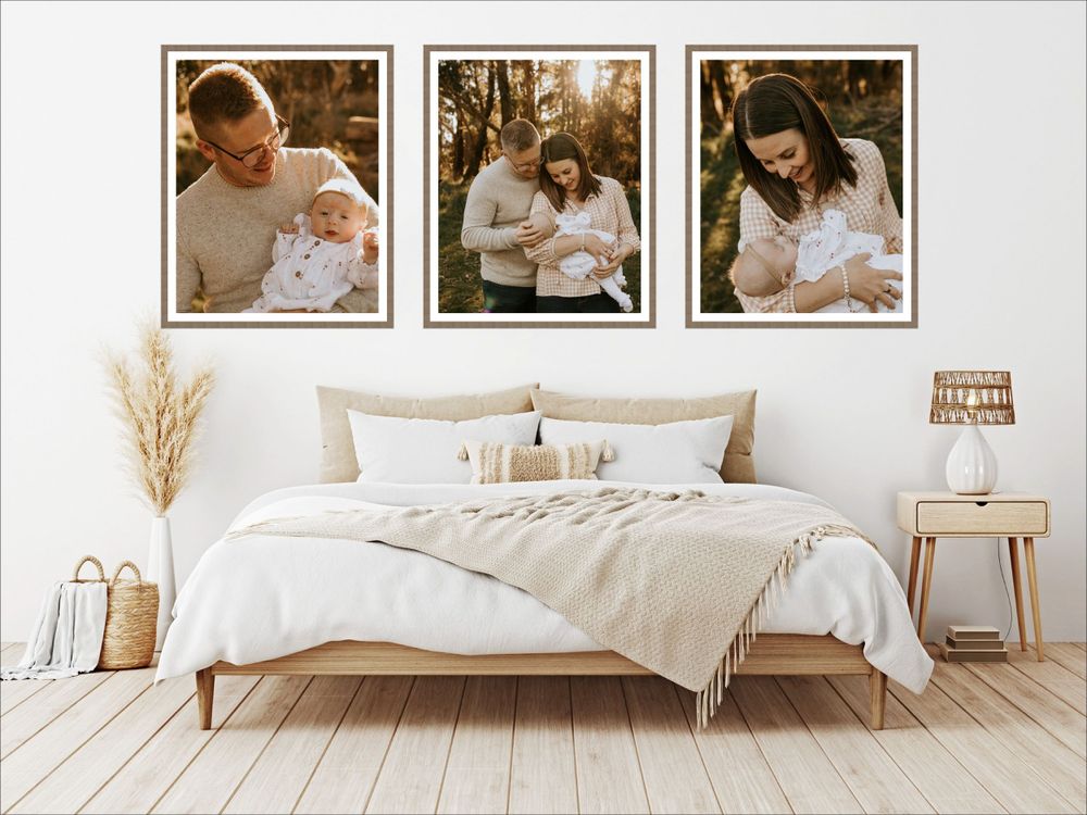 Modern bedroom wall gallery featuring family photographs above white bedding and natural decor.