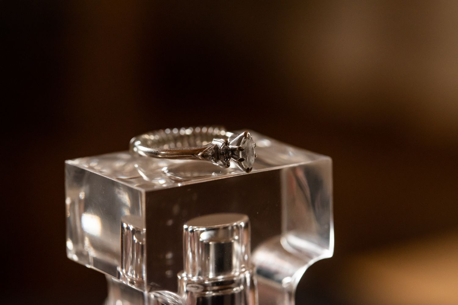 Close-up details of wedding rings on a crystal clear glass surface.