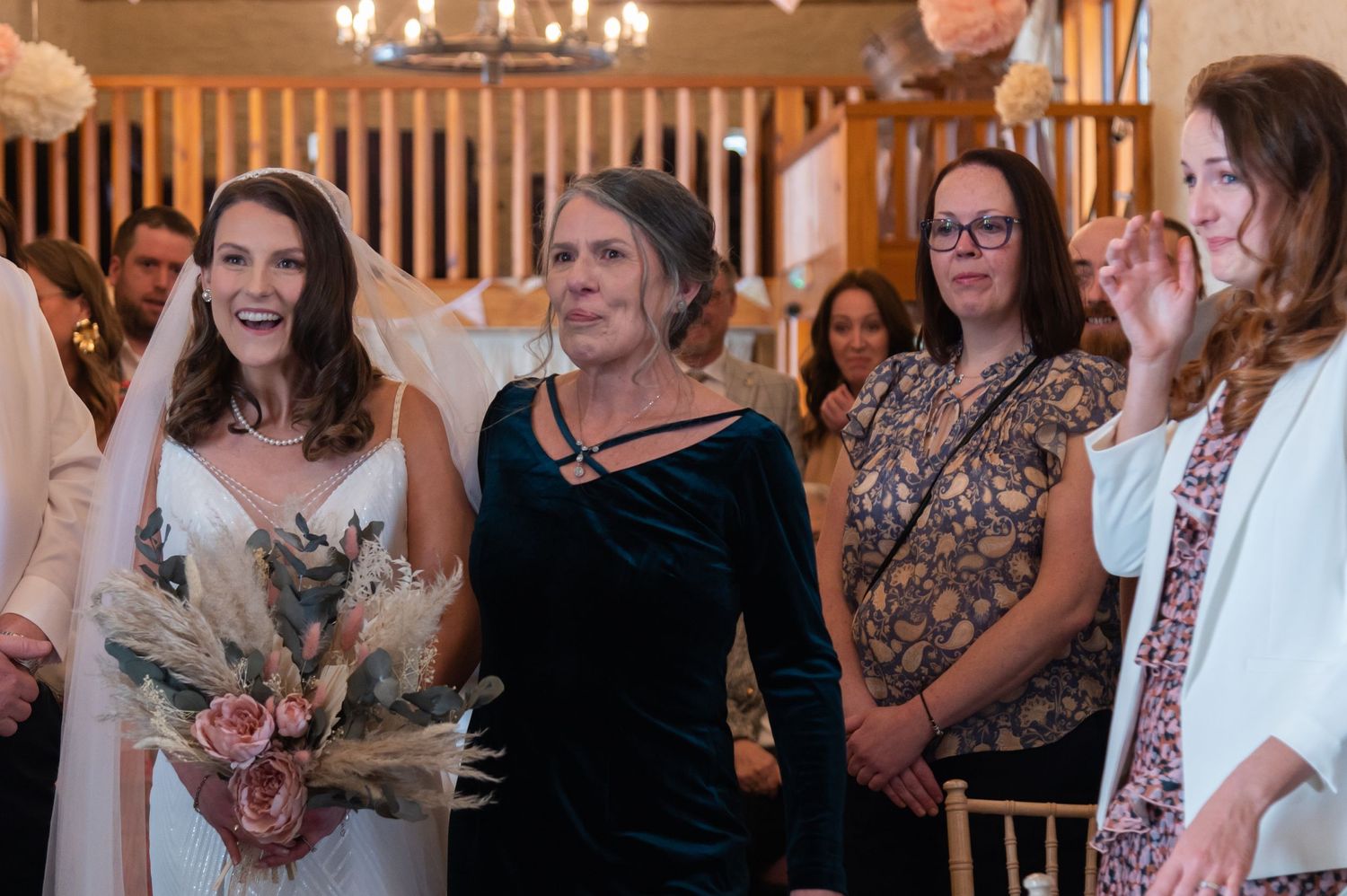 Guests enjoying a celebration in an indoor venue with a chandelier.