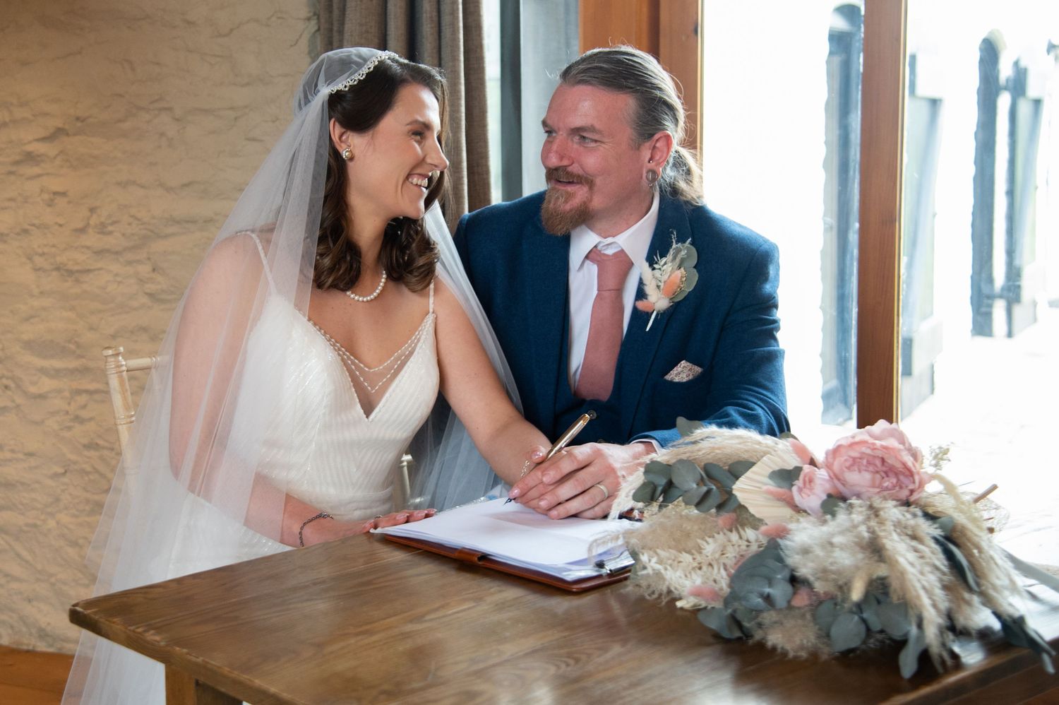 Couple signs marriage documents during their wedding ceremony.