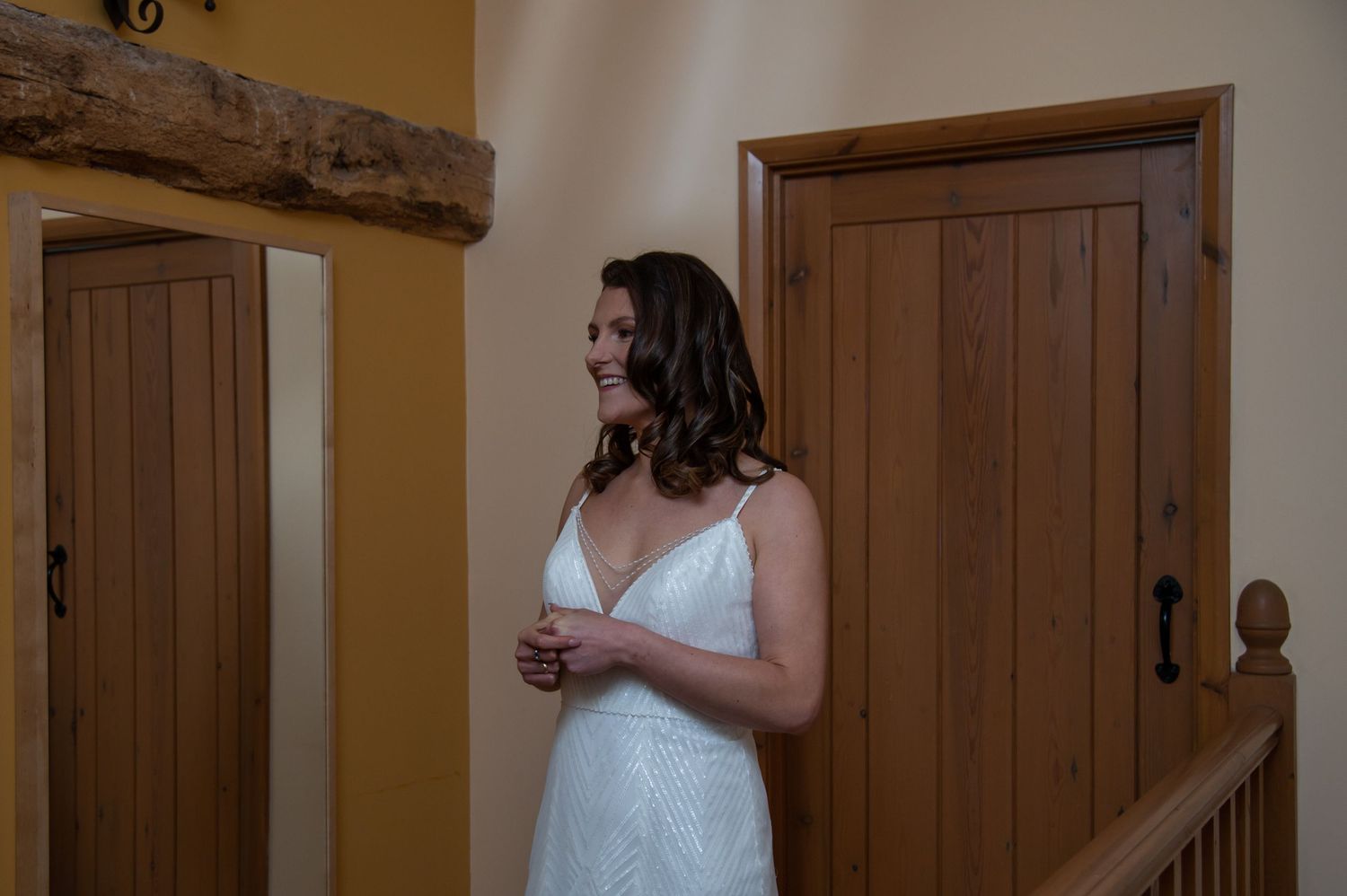 White wooden doors and rustic beams add charm to wedding venue interior.