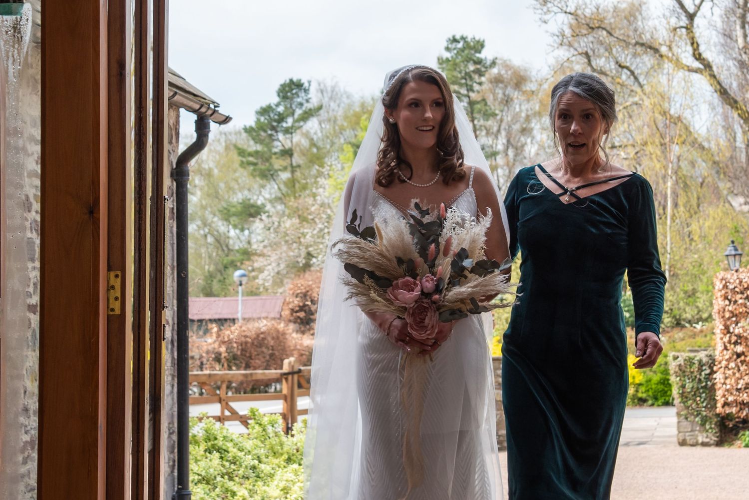 Natural light streams through wooden doorways during an indoor wedding ceremony.