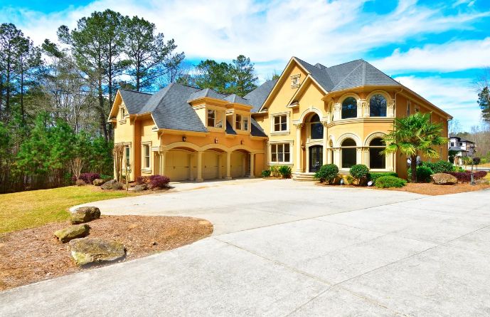Luxurious stone and stucco mansion with three-car garage and professionally landscaped yard.