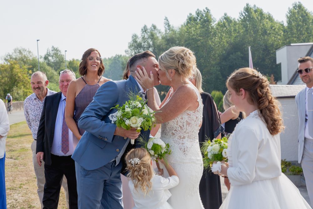 A wedding celebration gathering with guests and flowers on a bright sunny day.