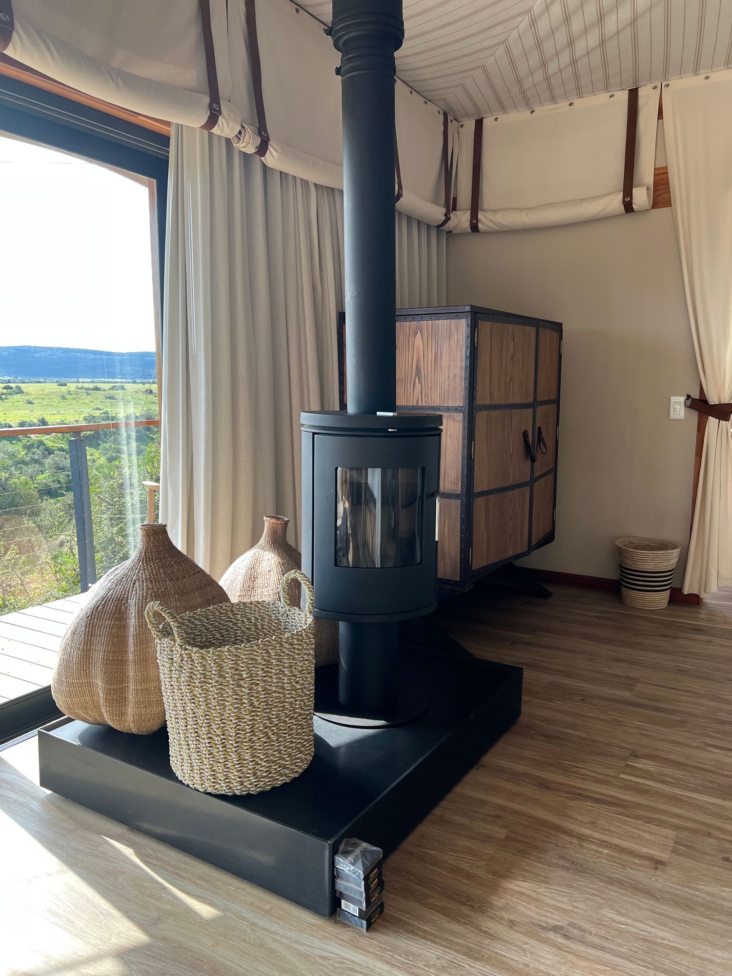 Modern living space with black wood stove and woven basket decor on hardwood floors.