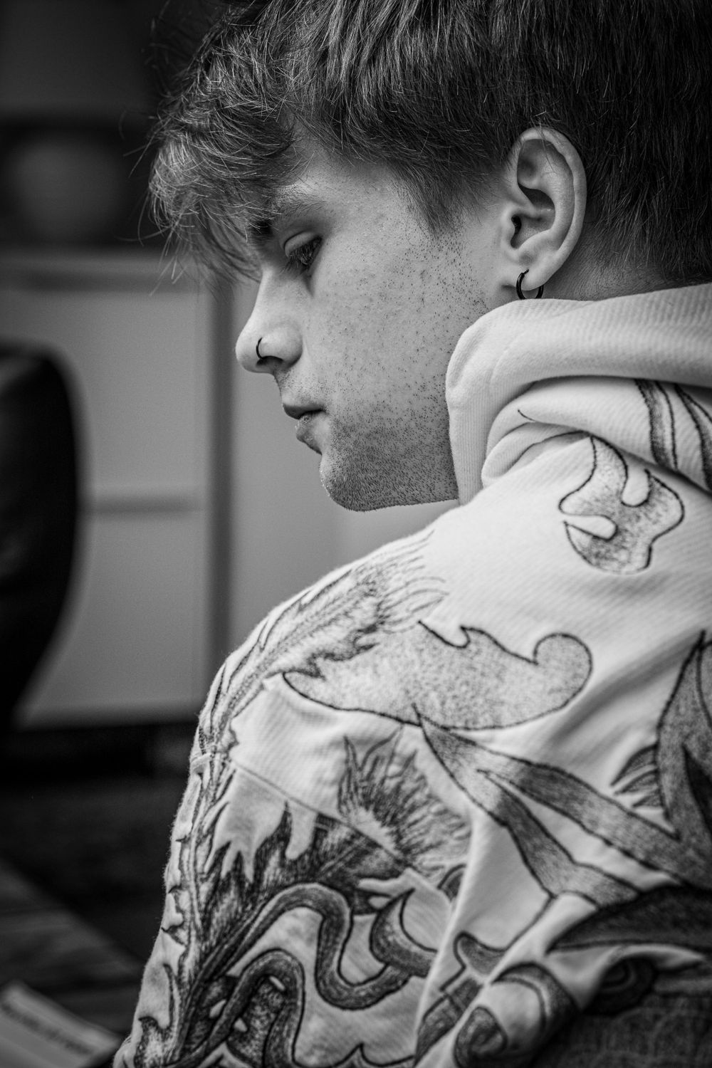 schwarz weiss portrait eines jungen Mannes mit Kapuzenpulli