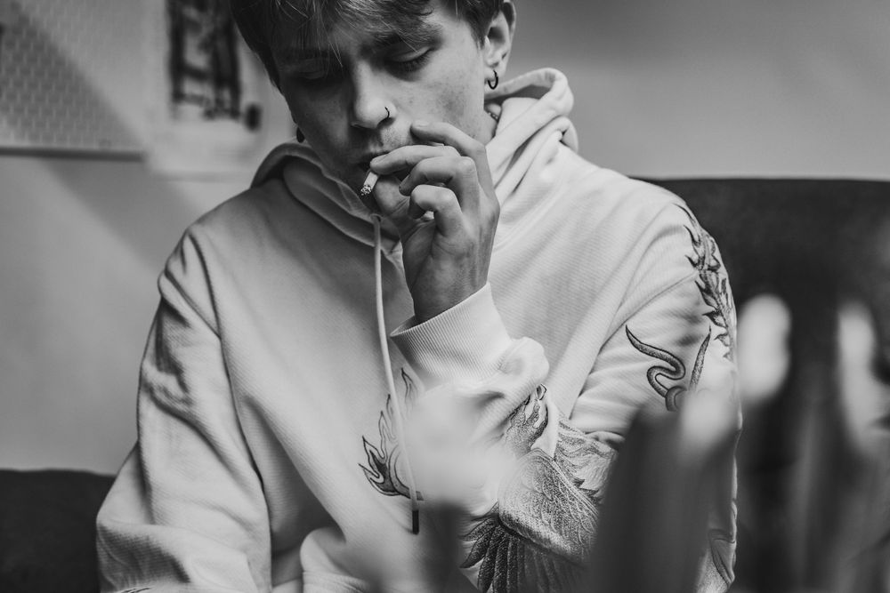 schwarz weiss portrait eines jungen Mannes beim rauchen