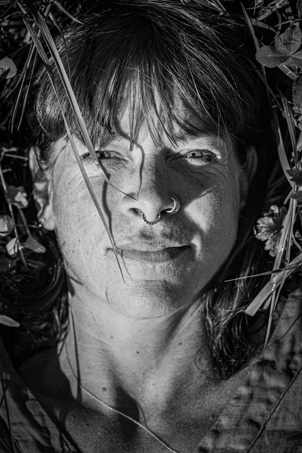 schwarz weiss portrait einer Frau liegend auf der Wiese