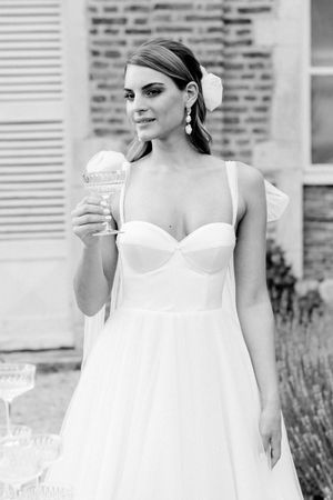 Bride in her beautiful flowing wedding gown with a glass of Champagne during her destination wedding in France.