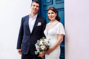 Bride and groom in front of a nice and colourful wall at their Chelsea Town Hall wedding in London. London wedding photographer