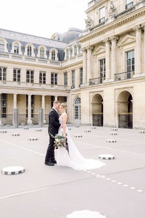 Bride and groom during their destination wedding in Paris. In the iconic courtyard with the black and white columns.