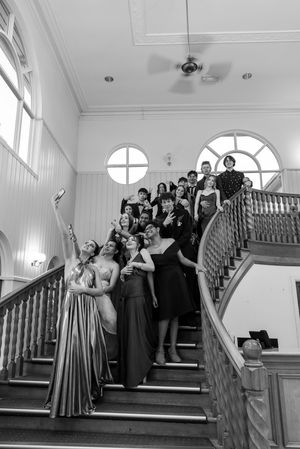 Black and white photo of formal group posing on grand staircase.
