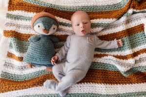A baby lying on a striped knit blanket in various poses showing growth and movement over time.