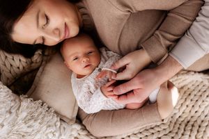 Intimate moment between mother and baby on cozy knit blanket.
