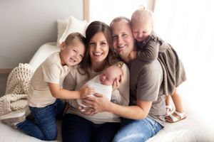 A family shares a tender moment together while sitting on a cozy bed.