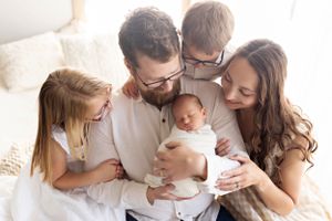 Intimate family lifestyle session with soft white studio lighting and natural poses.
