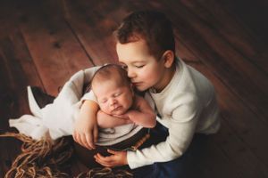 Close-up black and white newborn photography session showing tender intimate moments and details.