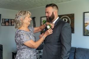 Touching moment during wedding preparations in a home living room setting.