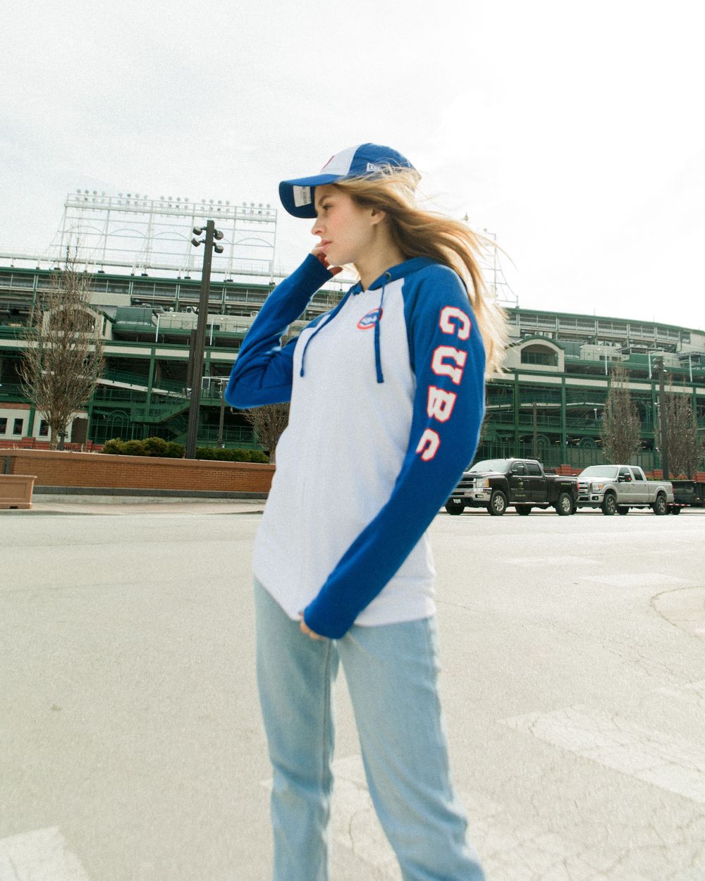 Cubs merchandise fashion shoot featuring blue and white baseball gear outside stadium.