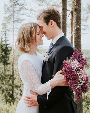 Portrett av brudepar tatt i skogen. De holder rundt hverandre og lener panne mot panne.