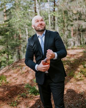 Forlover står i skogen og spretter en flaske med bobler